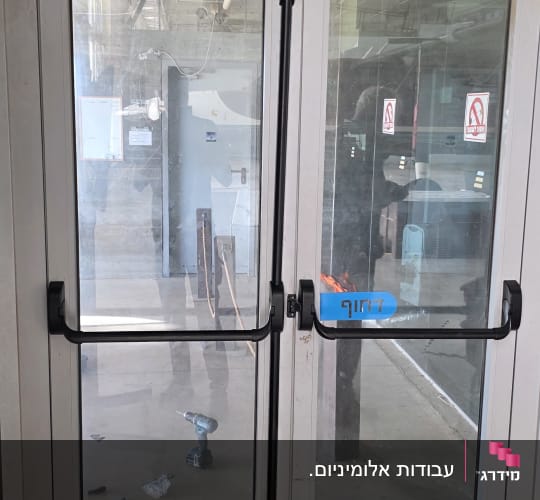 התקנת דלתות אלומיניום כפולות עם זכוכית וידיות בהלה